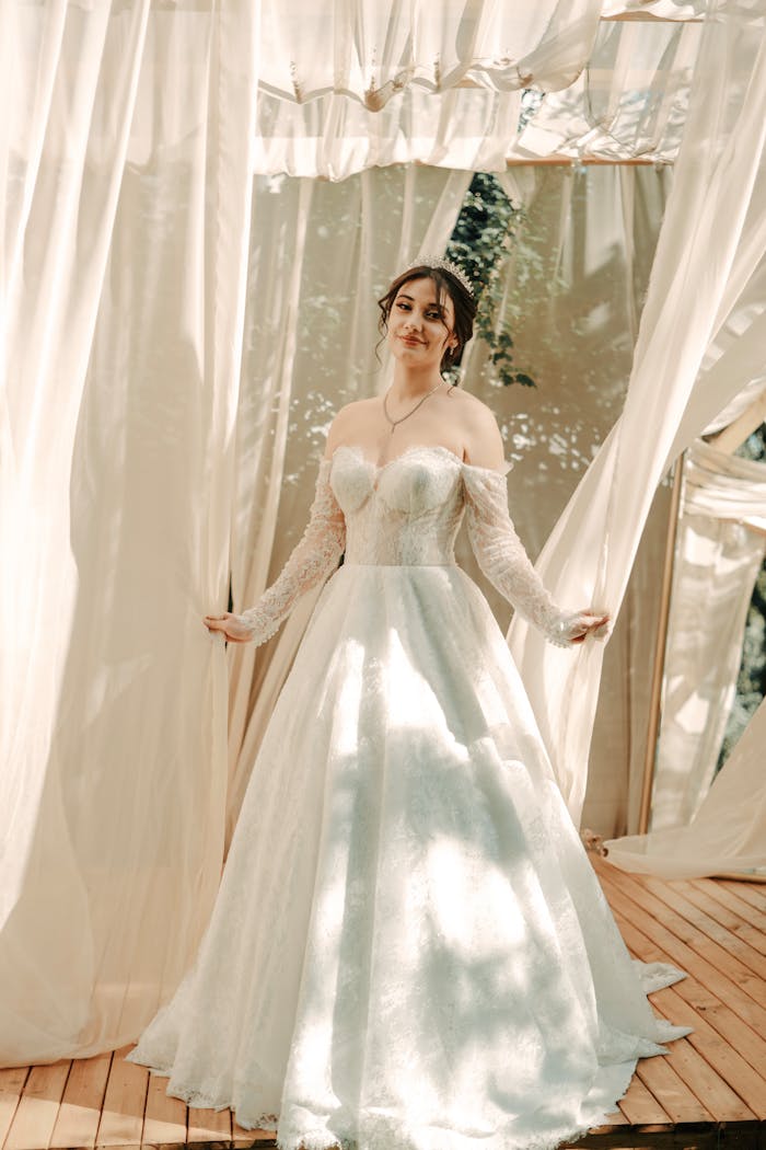 gallery-3 A beautiful bride in a white gown posing gracefully at an outdoor wedding venue.