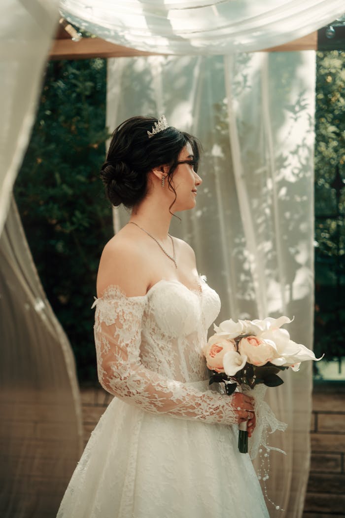 why-choose-us Beautiful bride in lace wedding dress holding a bouquet in outdoor ceremony.